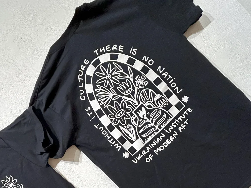 Black UIMA T-shirt printed with an arched floral design and the words “Without its culture there is no nation”